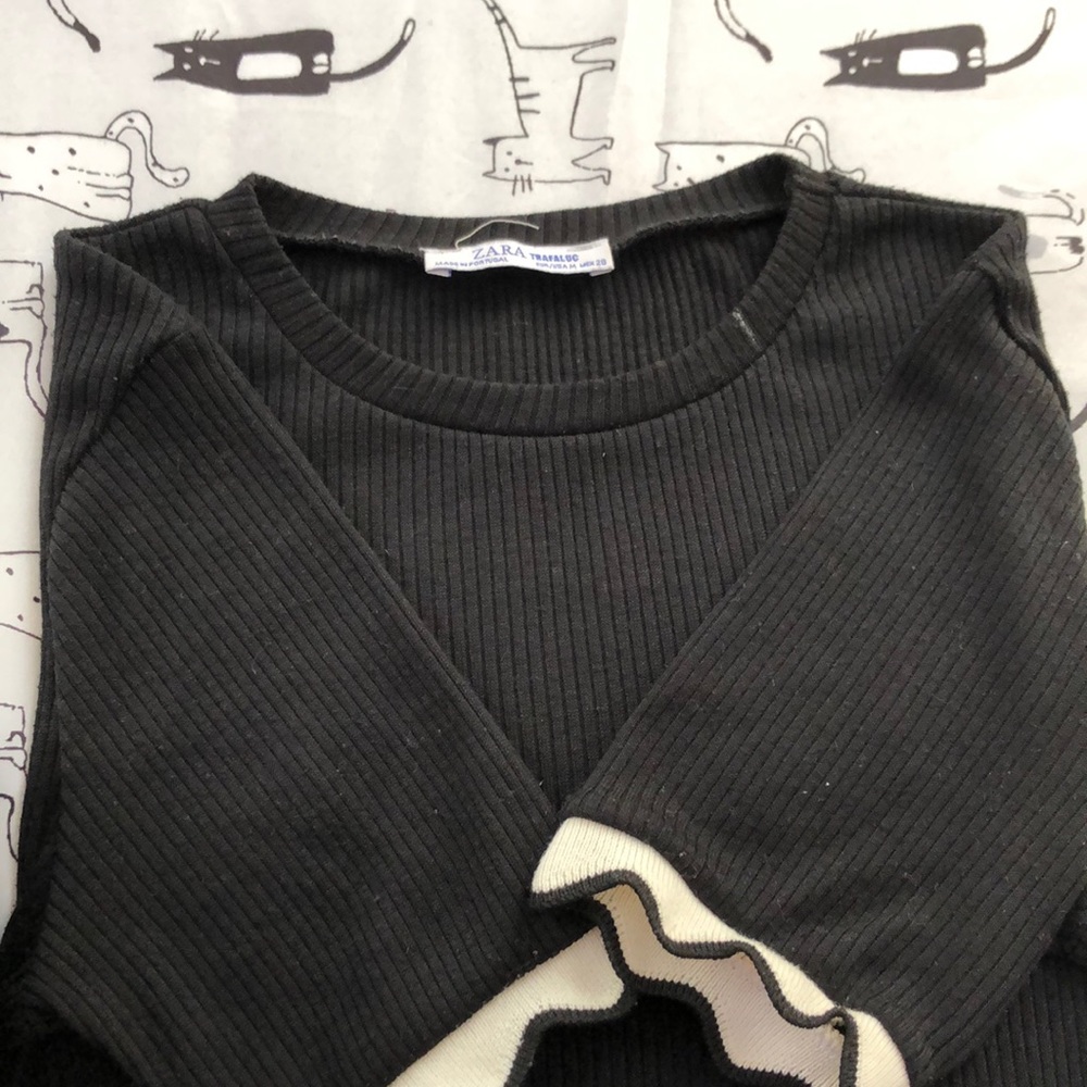 Black t-shirt with white frills on the sleeves
